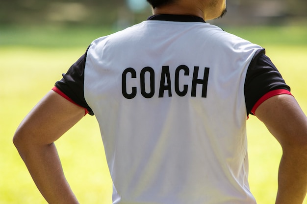 Vista posterior del entrenador de fútbol o fútbol masculino en camisa  blanca con la palabra coach escrita en la parte posterior | Foto Premium