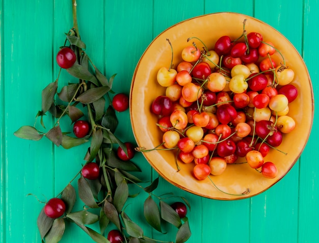 Vista superior de cerezas maduras más lluviosas en placa amarilla con