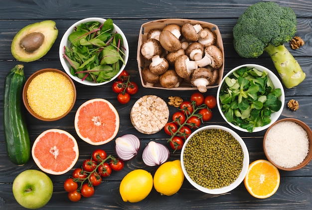 Vista superior de los cítricos; verduras y legumbres en mesa negra. Foto gratis