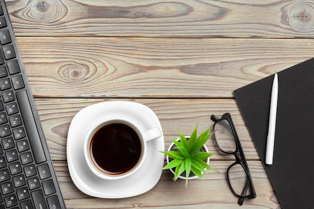 Vista superior del escritorio de madera con gafas y artículos de papelería de cerca. bosquejo Foto Premium