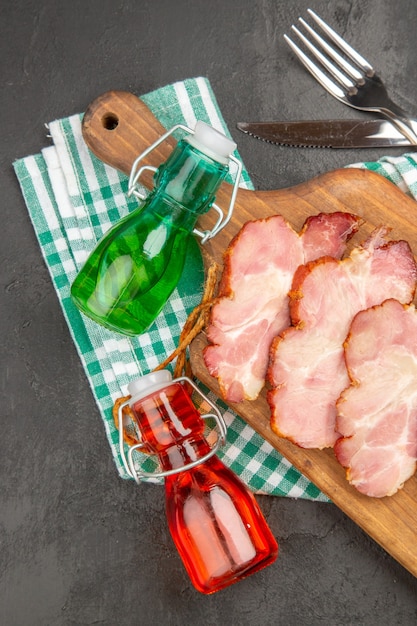 Vista superior de jamón fresco en rodajas sobre un escritorio de madera