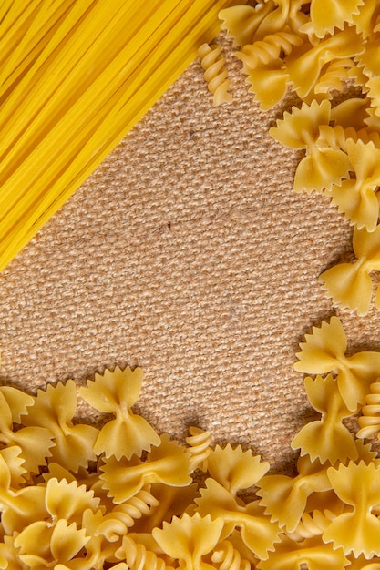 Foto Gratis Una Vista Superior De Pasta Italiana Cruda Pequena Y Larga Formada Repartida Por Toda La Bolsa Marron Pasta Comida Italiana