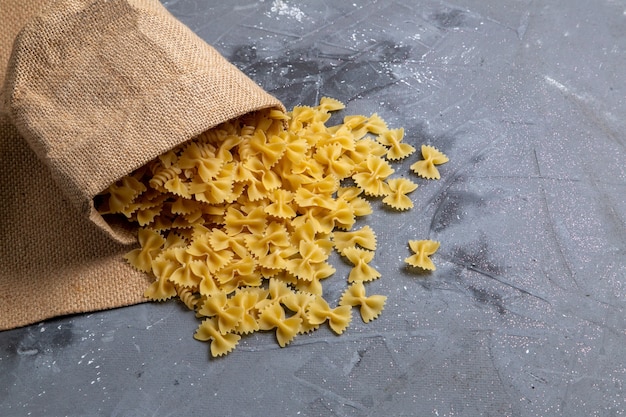 Una Vista Superior De Pasta Italiana Cruda Poco Formada Dentro De La Bolsa En El Escritorio Gris Pasta Comida Italiana Foto Gratis