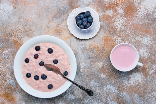 Vista superior del plato con gachas de avena con yogur de arándanos