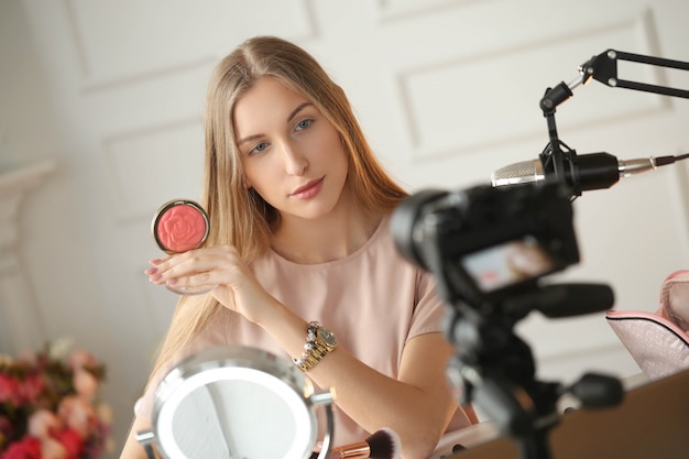 Vlogger de belleza. mujer joven grabando un tutorial de maquillaje Foto gratis