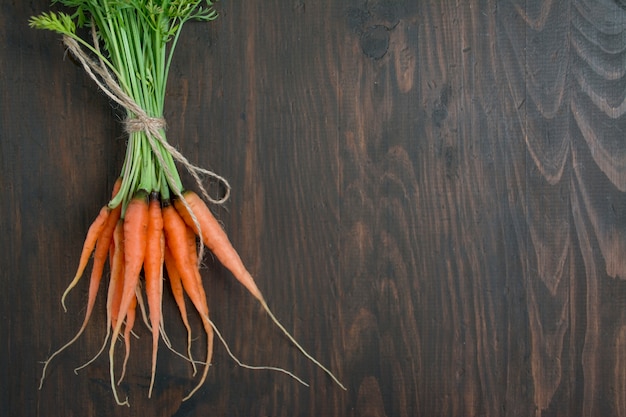 Zanahorias frescas sobre una plancha de madera vieja. zanahorias jóvenes balance de comida saludable. menú de fondo de la tabla. espacio para texto. Foto Premium