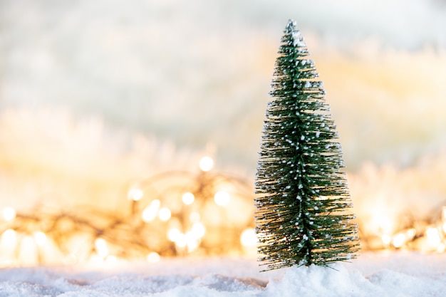 Sfondi Natalizi Con Neve.Albero Di Natale Sulla Neve Con Regalo E Sfondi Luce Bokeh Foto Premium