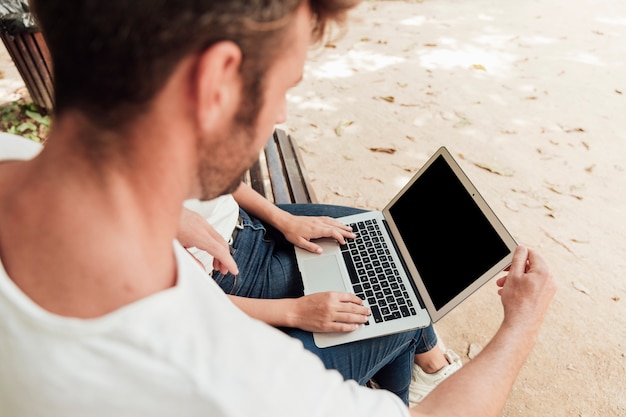Amici che passano in rassegna su un computer portatile all'aperto Foto Gratuite
