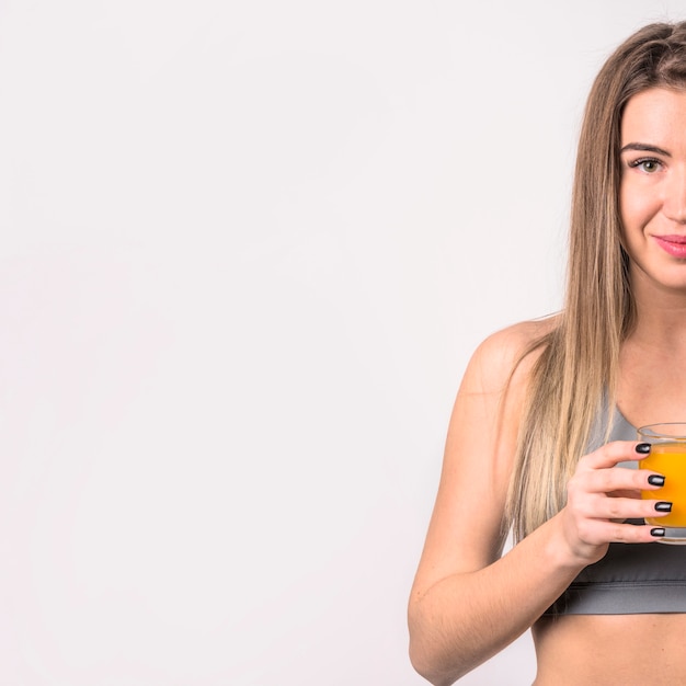 Attraente donna allegra con un bicchiere di succo Foto Gratuite