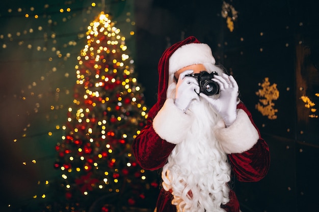 Babbo natale facendo foto sulla fotocamera | Foto Gratis