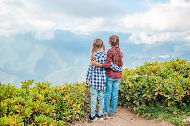 Belle bambine felici in montagna sullo sfondo della nebbia Foto Premium