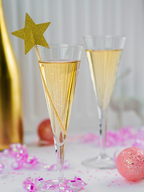 Bicchieri di champagne con nastro rosa e stella Foto Gratuite