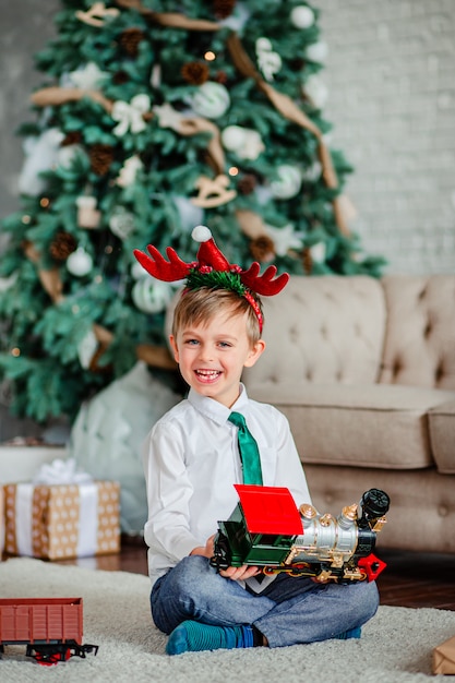 Immagini Buongiorno Di Natale.Buongiorno Ragazzino Felice Con Un Regalo Trenino Sotto L Albero Di Natale E Ora Di Soddisfare I Desideri Foto Premium