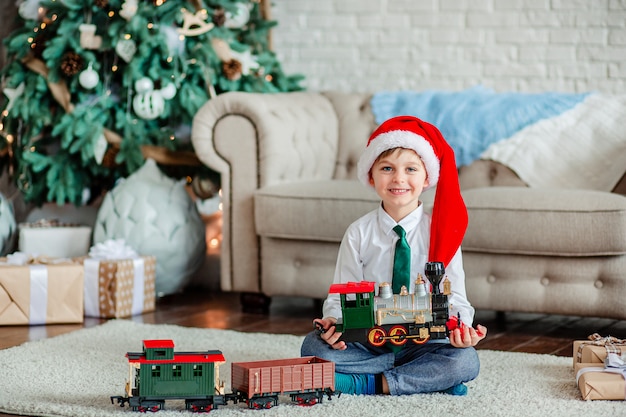 Immagini Buongiorno Di Natale.Buongiorno Ragazzino Felice Con Un Regalo Trenino Sotto L Albero Di Natale E Ora Di Soddisfare I Desideri Foto Premium