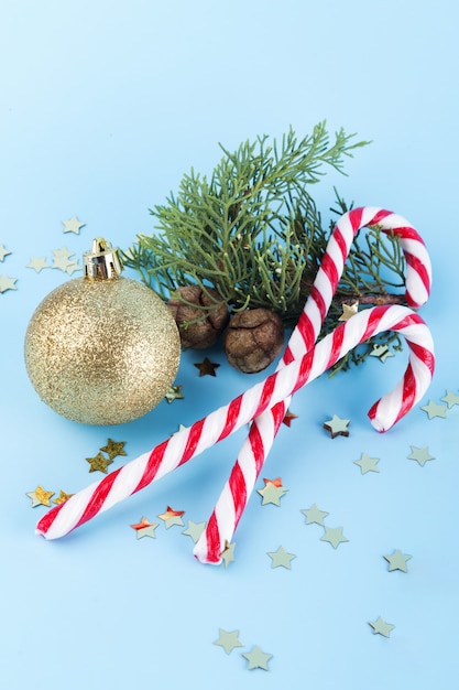 Canne di caramella di natale con la sfera dorata di natale e la filiale attillata. sfondo, sfondi, carta da parati, banner, striscioni, vernice, fondale, modello, tessile, carta, invito, auguri, cartolina, icona, icone, logo, emblema, logotipo, simbolo, segno, segni, timbro, etichetta, distintivo, st Foto Premium