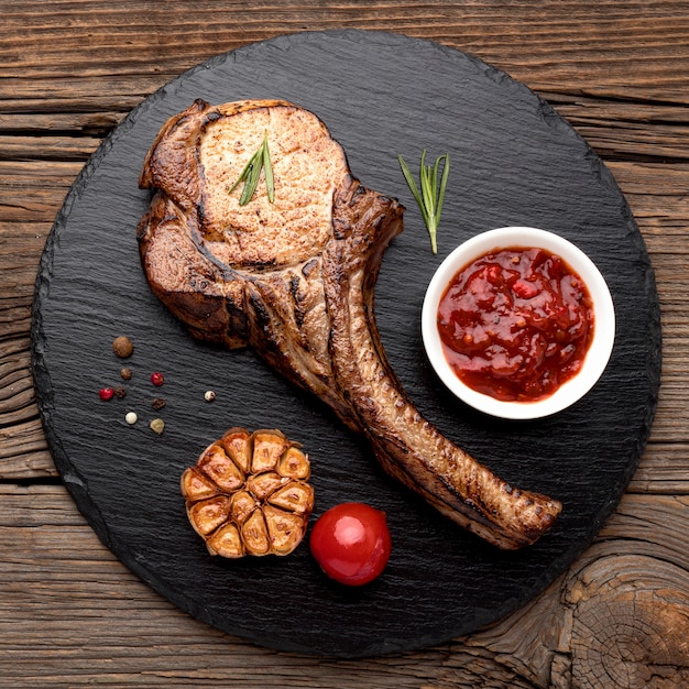 Carne cotta con salsa sul bordo di legno | Foto Gratis