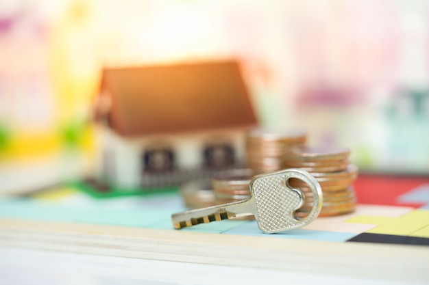 Casa chiave e modello di casa come sfondo. concetto per la scala di proprietà, l'ipoteca e l'investimento immobiliare. Foto Premium