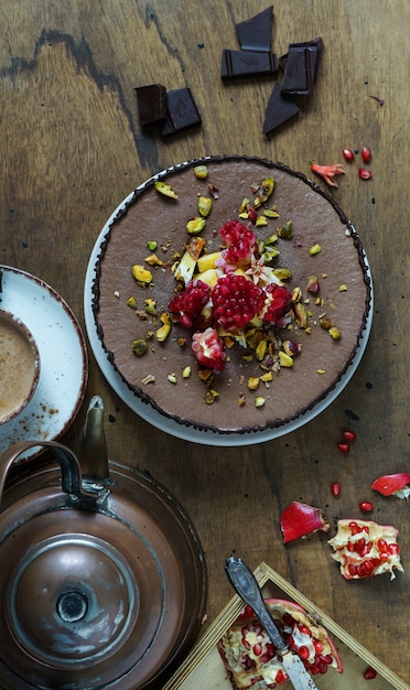 Cheesecake cruda vegana con mirtilli, ciliegia, tè matcha, arancia, crema di anacardi, burro di cocco e latte di cocco e base a base di mandorle, datteri e albicocche secche, fiocchi d'avena, bacche liofilizzate Foto Premium