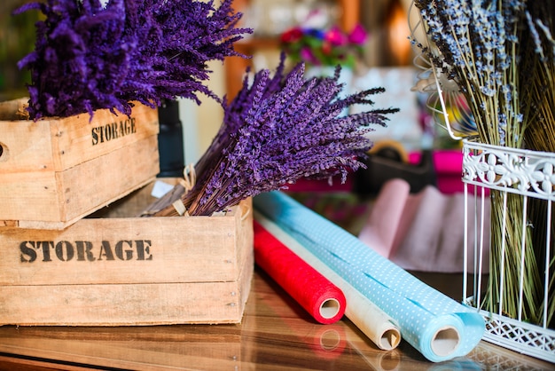 Chiuda su del mazzo dei fiori della lavanda in una gabbia del metallo e in una scatola di legno Foto Premium