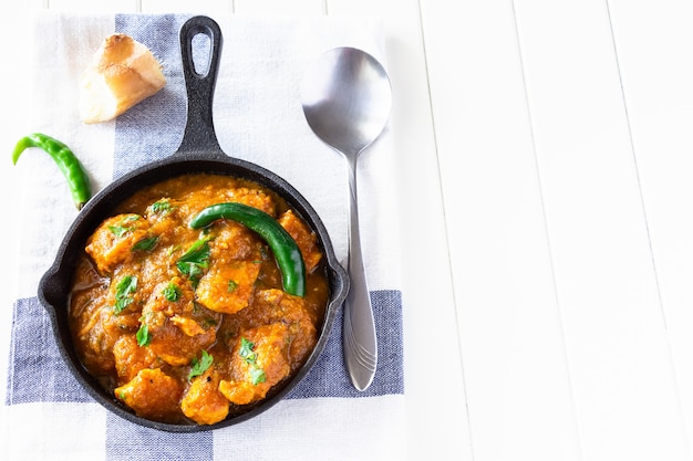 Chiuda sul curry e sul limone del pollo del burro indiano tradizionale serviti con il pane di chapati su ghisa. vista dall'alto. copia spazio Foto Premium