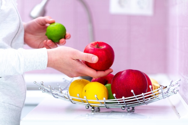 Ciotola di frutta matura fresca sulla tavola in cucina a casa. vitamine, prodotti biologici ecologici per merenda sana. cibo pulito, corretta alimentazione. dieta Foto Premium
