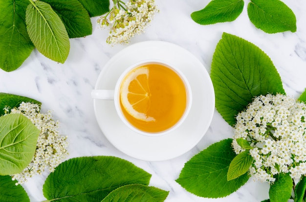 Composizione piatta di tè con fiori Foto Gratuite