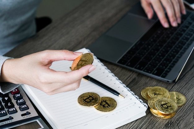 Computer portatile con calcolatrice e bitcoin dorato. concetto di investitori di criptovaluta. Foto Premium