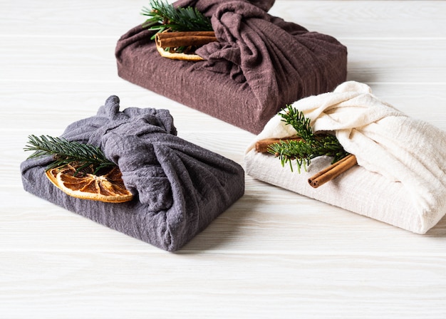 Confezioni regalo riutilizzabili in tessuto ecologico con brunch di abete, stecca di cannella e fettina d'arancia secca. alternativa di confezione regalo riutilizzabile sostenibile di natale. concetto di rifiuti zero. copia spazio Foto Premium