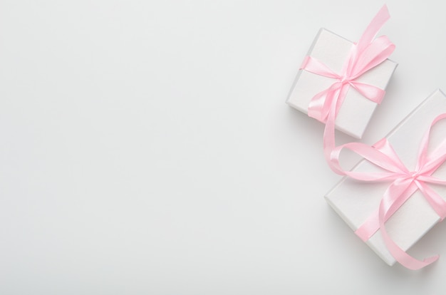 Contenitori di regalo con il nastro rosa su fondo bianco. Foto Premium