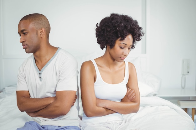 Coppia sconvolgente che non parla dopo una discussione seduta sul letto Foto Premium