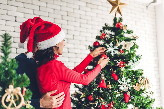 Immagini Romantiche Di Natale.Coppie Dolci Romantiche In Cappelli Di Santa Divertendosi Decorando L Albero Di Natale E Sorridendo Mentre Celebrando La Notte Di San Silvestro Foto Premium