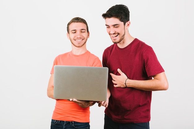 Coppie gay felici che esaminano taccuino Foto Gratuite