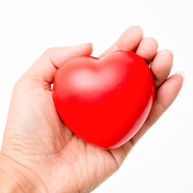 Cuore rosso in mano isolato su sfondo bianco illuminazione da studio. Foto Premium