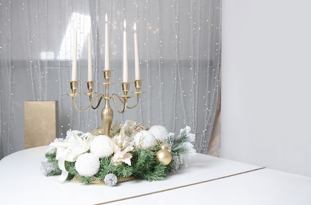 Decorazioni di capodanno e un candelabro d'oro con candele accese Foto Premium