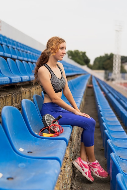 Donna allegra alla seduta dello stadio Foto Gratuite