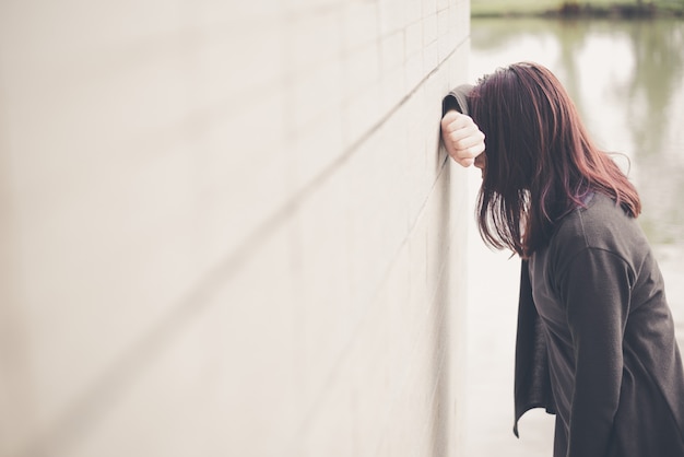 Donna asiatica che si siede da solo e depresso, ritratto di giovane donna stanca. depressione Foto Premium