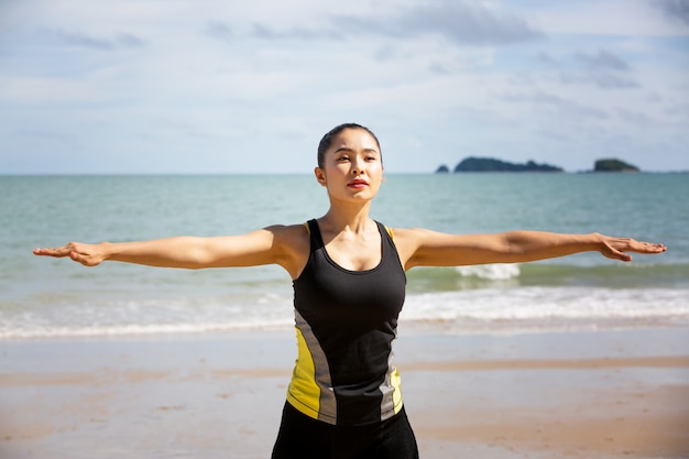 Donna Che Fa Esercizi Di Yoga Sulla Spiaggia Di Mattina Foto Premium