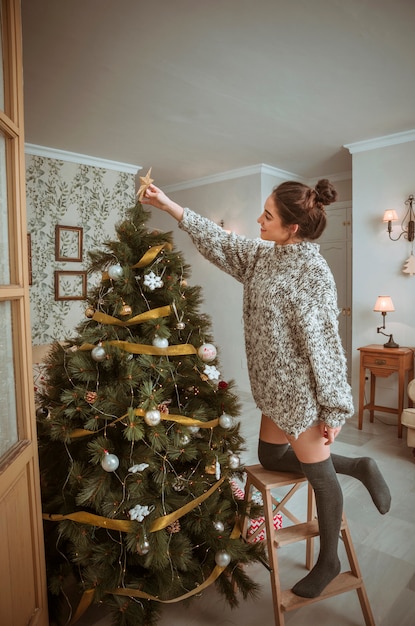 Immagini Di Natale Donne.Donna In Piedi Sulla Scala E Decorare L Albero Di Natale Foto Gratis