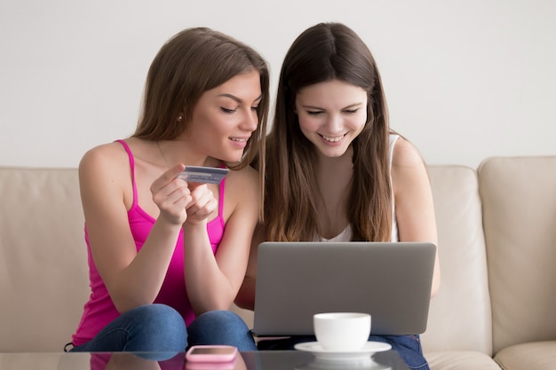Due amiche felici che ordinano merci in internet Foto Gratuite