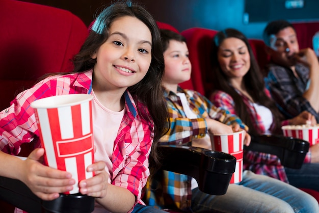 Famiglia felice che si siede nel cinema Foto Gratuite