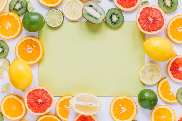 Frutti assortiti attorno al foglio di carta verde Foto Gratuite