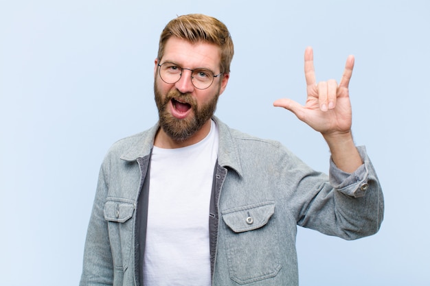 giovane-biondo-adulto-uomo-sentirsi-felice-divertente-fiducioso-positivo-e-ribelle-facendo-rock-o-heavy-metal-firmare-con-la-mano_1194-29840.jpg