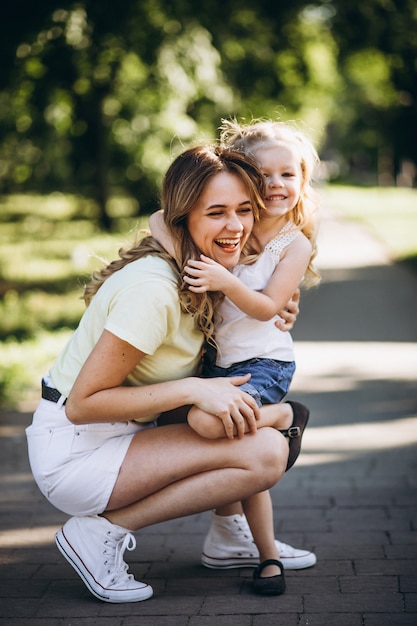 Giovane donna con la piccola figlia che cammina nel parco Foto Gratuite