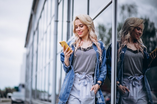 Giovane donna usando il telefono fuori Foto Gratuite