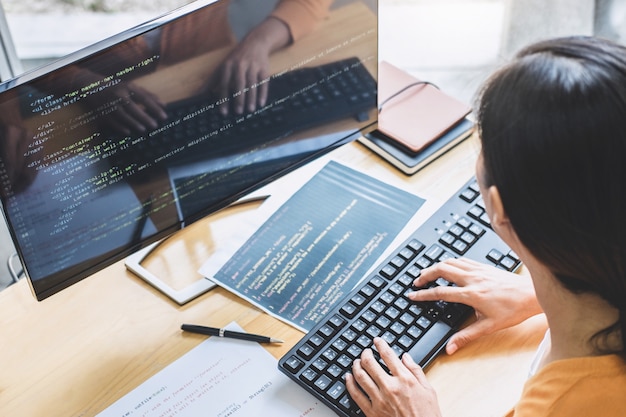 Giovane programmatore professionista che lavora nello sviluppo della programmazione e del sito web lavorando in un software per sviluppare uffici aziendali, scrivere codici e digitare codice dati, programmazione con html, php e javascript Foto Premium
