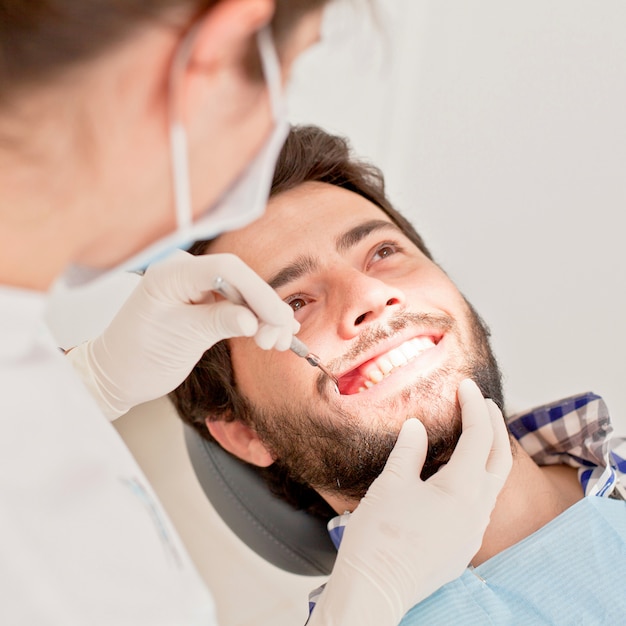 Giovane uomo felice e donna in una visita odontoiatrica al dentista Foto Premium