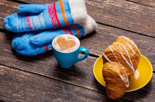 Guanti e tazza di caffè sul tavolo di legno. Foto Premium