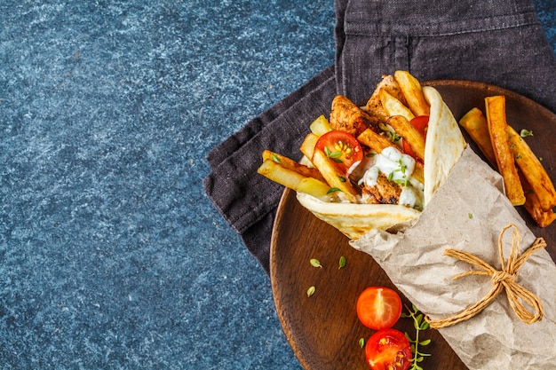 Gyros souvlaki si avvolge nel pane pita con pollo, patate e salsa tzatziki. Foto Premium
