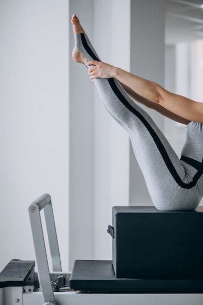 I pilates di pratica della donna in un riformatore dei pilates si chiudono su Foto Gratuite