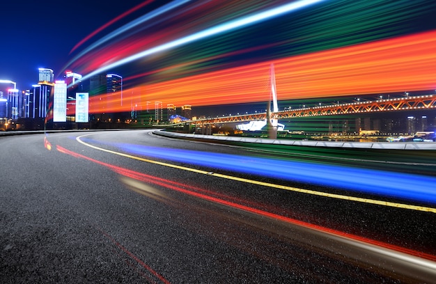 Immagine astratta di movimento della sfocatura delle automobili sulla strada di città alla notte, architettura urbana moderna a chongqing, cina Foto Premium